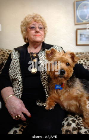 EINE WEIBLICHE RENTNER MIT EINEM LEOPARD SKIN SOFA UND WESTE WALES UK Stockfoto