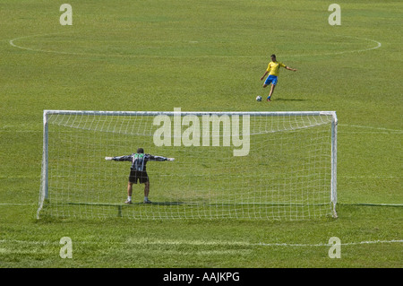 Fußball-Spieler treten Ball in Richtung Tor, Stockfoto