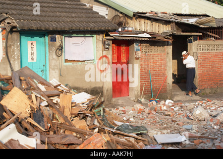 Alter Mann in Haus, umgeben von Bauschutt Stockfoto