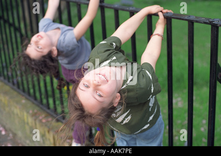 Zwei sechs Jahre alten Mädchen spielen auf Metallgeländer, London, UK. Stockfoto