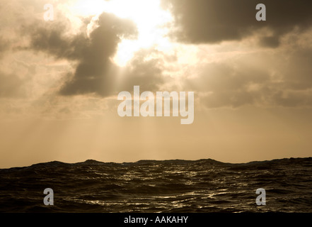 Dramatischen Sonnenuntergang Sonnenaufgang über eine wellige Ozean Stockfoto