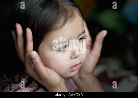 Mutter hat ihre Tochter Gesicht in ihre Hände Stockfoto