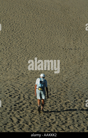 Ein Senior-Mann geht auf Sanddünen am Strand Playa Ingles in Maspalomas auf Gran Canaria, einer der Kanarischen Inseln Spaniens, spazieren Stockfoto