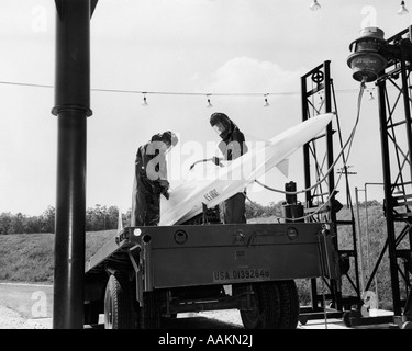 1960ER JAHREN US ARMEE NIKE GEFÜHRTE-RAKETE AUF DER STARTRAMPE WIRD ANGEHEIZT KRAFTSTOFF VON 2 MÄNNERN IN FEUERBESTÄNDIGE KLEIDUNG Stockfoto