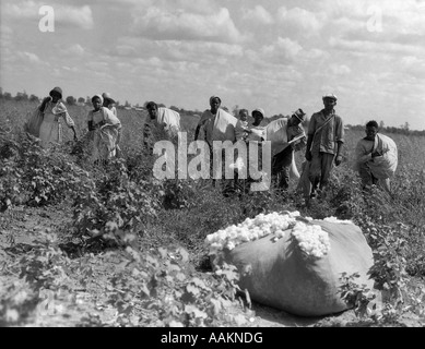 1930ER JAHRE GRUPPE DER AFRIKANISCHEN AMERIKANISCHEN ARBEITER MIT TASCHEN AUS BAUMWOLLE IM FELD LOUISIANA IM FREIEN Stockfoto