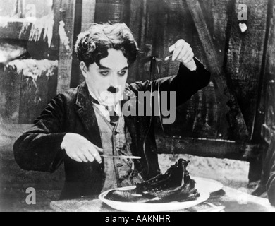 1920ER JAHRE CHARLES CHAPLIN ESSEN SCHUH IN SZENE AUS 1925 FILM GOLDRAUSCH Stockfoto