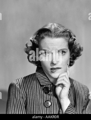 1950S 1960S FRAU IM GESTREIFTEN KLEID MIT KNÖPFEN HAND BIS ZUM KINN COMIC BESORGT AUSDRUCK BLICK IN DIE KAMERA Stockfoto