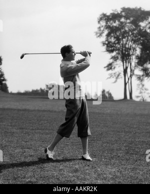 1930ER JAHREN GOLFER IM SCHLÜPFER MIT CLUB IN LUFT Stockfoto