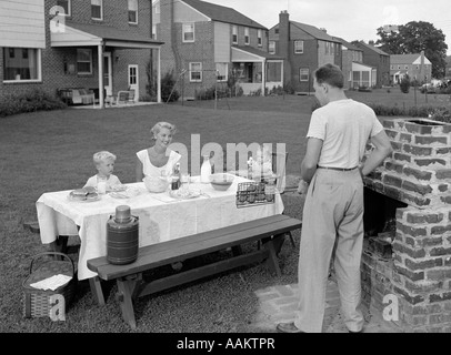 1940S 1950S FAMILIE IM GARTEN KOCHEN HAMBURGER Stockfoto