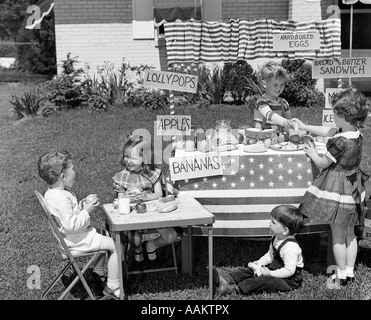 1950ER JAHREN KINDER IM GARTEN SPIELEN STORE MIT ZEICHEN VERKAUFEN ÄPFEL BANANEN-SANDWICHES-LUTSCHER Stockfoto