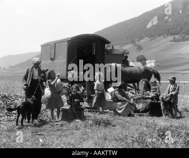 1930ER JAHREN SCHWEIZER NOMADEN MIT ZIGEUNERWAGEN GEKLEIDET IN BÄUERLICHEN KLEIDUNG IN ALPINEN WIESENTAL Stockfoto