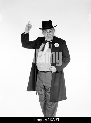 DER 1950ER JAHRE DER 1960ER JAHRE MANN TRAGEN OLDTIMER POLITIKER GEHROCK MIT KAMPAGNE PIN SCHALTFLÄCHE "ZURÜCK" ZEIGT INDEX FINGER IN LUFT SUCHEN AT Stockfoto