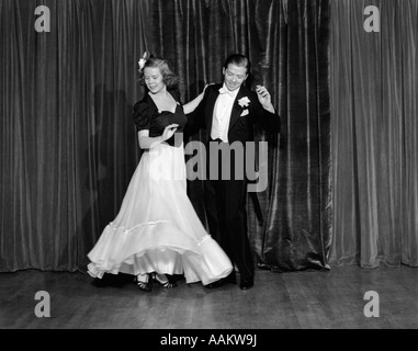 1940ER JAHREN PAAR MANN UND FRAU IN ABENDGARDEROBE BALLROOM TANZEN AUF DER BÜHNE Stockfoto