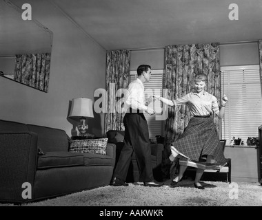 1950ER JAHRE TEEN PAAR JITTERBUG ROCK'N'ROLL TANZ IM WOHNZIMMER MANN FRAU JUNGE MÄDCHEN ZU TUN Stockfoto