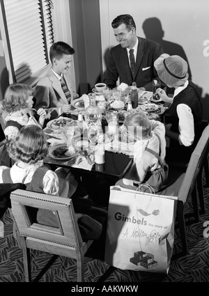 1950ER JAHRE FAMILIE VON SECHS ESSEN SEIT LANGEM RESTAURANT EINKAUFEN Stockfoto