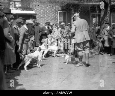 1920S 1930S JAGD-HUNDE UND BESITZER FÜR FELDVERSUCHE VOR BACKSTEINGEBÄUDE MONTIERT Stockfoto