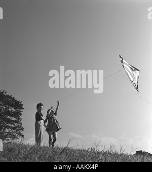 1940ER JAHREN JUNGEN UND MÄDCHEN AM HANG FLIEGEN KITE Stockfoto