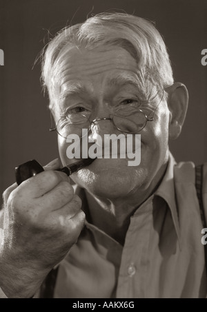 1930S 1940S MANN LÄCHELND CHARAKTER ÄLTERE WEIßE HAARE PFEIFE BLICK IN DIE KAMERA Stockfoto