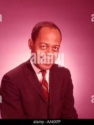 1960ER JAHRE PORTRAIT LÄCHELND AFROAMERIKANISCHE MANN TRAGEN BUSINESS-ANZUG Stockfoto