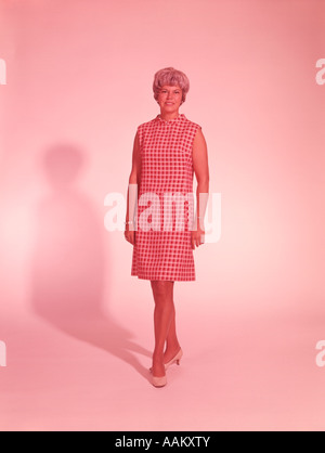 1960ER JAHRE VOLLER LÄNGE PORTRAIT FRAU IN ROTEN UND WEIßEN KLEID Stockfoto