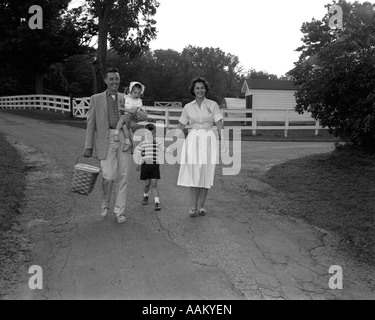 1950ER JAHRE FAMILIE HINUNTER FELDWEG MIT PICKNICK-KORB Stockfoto