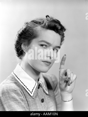 1940ER JAHREN FRAU HIELT IHRE HAND MIT EINER SCHNUR GEBUNDEN UM IHREN ZEIGEFINGER WIE EINE ERINNERUNG, BLICK IN DIE KAMERA Stockfoto