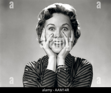 1950S 1960S PORTRÄT VERRÜCKTE FRAU DIE HÄNDE AUF GESICHT MIT LÄCHELNDEN AUFGEREGT LUSTIGE SMILEY BLICK IN DIE KAMERA Stockfoto