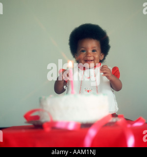 1970ER JAHREN WEICHZEICHNER PORTRAIT AFRICAN AMERICAN BABY LÄCHELT GEBURTSTAGSKUCHEN MIT EINER KERZE Stockfoto