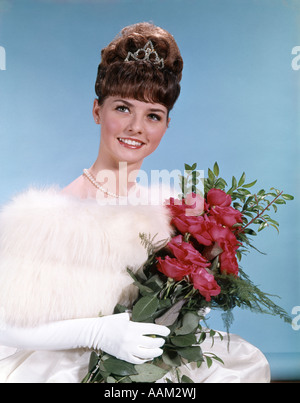 1960ER JAHRE JUNGE TEENAGER FRAU IM ABENDKLEID HOLDING BOUQUET ROSEN BIENE BIENENSTOCK FRISUR TIARA PROM SCHÖNHEITSKÖNIGIN MODE Stockfoto