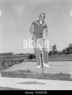 1950ER JAHRE JUNGE SPRINGT AUF POGO STICK Stockfoto