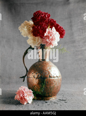 1960ER JAHREN GEHÄMMERT KUPFER VASE ROSA ROT WEIßE NELKEN EINFACHE GRAFISCHE FLORA ANORDNUNG STILLLEBEN MUTTERTAG Stockfoto
