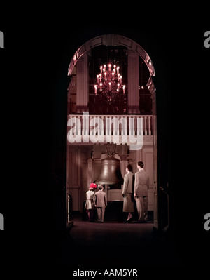 1950ER JAHRE FAMILIE GESEHEN DURCH HOHEN BOGEN AN DER LIBERTY BELL BEI NOCH INNEN UNABHÄNGIGKEITSHALLE PHILADELPHIA PENNSYLVANIA USA Stockfoto