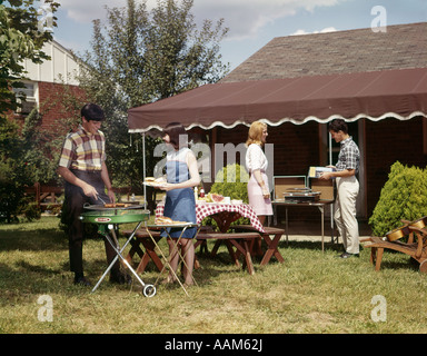 1960ER JAHRE ZWEI TEENAGER PAARE BEIM BARBECUE IN EINEM VORORT HINTERHOF JUNGE MÄDCHEN Stockfoto