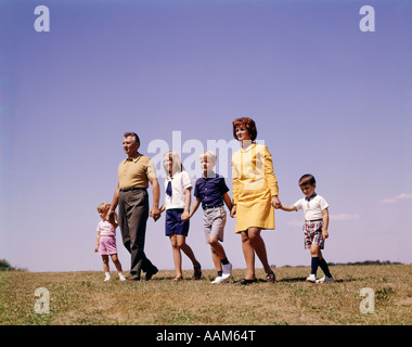 1960ER JAHRE VORWÄRTS FAMILIE VATER MUTTER TOCHTER 3 SÖHNE GEHEN GEMEINSAM HAND HÄLT NOSTALGIE RETRO VINTAGE EINHEIT Stockfoto