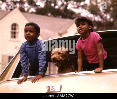 1970 1970S AFROAMERIKANISCHEN KINDERN JUNGE MÄDCHEN HAUSTIER HUND HECKSCHEIBE KOMBI FAMILIENAUTO MIT BLICK Stockfoto