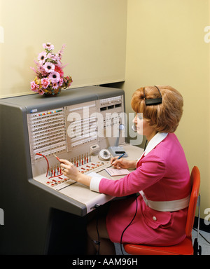 1970s WOMAN WORKING AT PBX TELEPHONE SWITCHBOARD Stockfoto