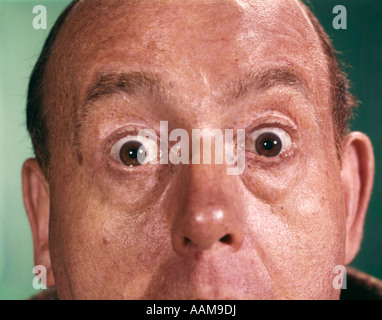 1960ER JAHRE NAHAUFNAHME DETAIL DER FLORIDEN MANN GESICHT MIT AUGEN ÖFFNEN WEIT UND STARR Stockfoto