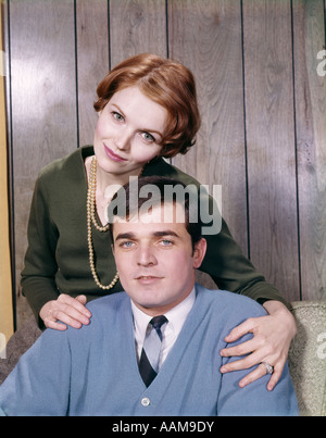 1960ER JAHRE PORTRAIT PAAR MANN PULLOVER KRAWATTE FRAU STÜTZTE SICH AUF SEINE SCHULTERN PERLENKETTE MANN FRAU RETRO Stockfoto
