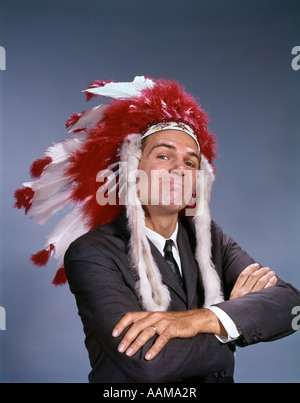 1960ER JAHREN CHARAKTER TRAGEN NATIVE AMERICAN INDIAN FEDER KOPFSCHMUCK CHIEF LEADER GESICHTS-AUSDRUCK ARME VERSCHRÄNKT GESTE Stockfoto