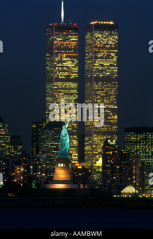 NEW YORK NY FREIHEITSSTATUE BEI NACHT ZWILLINGSTÜRME DES WORLD TRADE CENTER IM HINTERGRUND Stockfoto