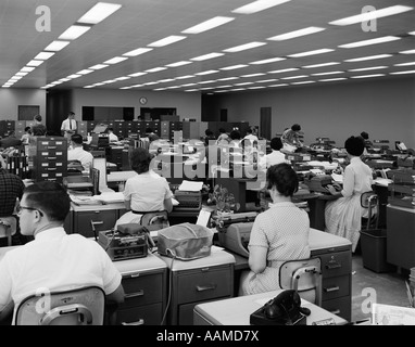 1960ER JAHREN RÜCKANSICHT VON MÄNNERN UND FRAUEN BEI SCHREIBMASCHINEN Stockfoto