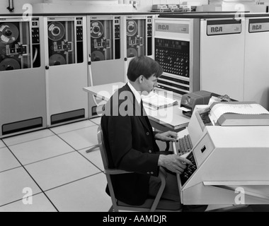 1960ER JAHREN SEITENANSICHT DES MANNES IN JACKE & TIE BETRIEB GROßE COMPUTER-TERMINAL Stockfoto