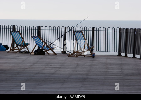 Liegestühle und Angelruten auf Hasting pier Stockfoto