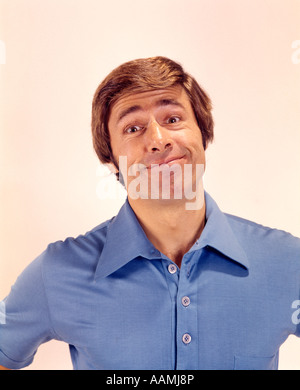 1970 1970S PORTRAIT MANN KOPF SCHULTERN LUSTIGE DUMME LÄCHELNDEN AUSDRUCK BLAUEN HEMD GRINSEN GESICHT GRINSEN GRINSEND LÄCHELN Stockfoto