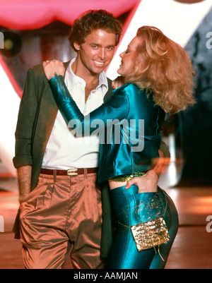 1970ER JAHREN LIEBEVOLL ROMANTISCH ZU ZWEIT IN KLEIDUNG MIT GLÄNZENDEN FINISH UMFASSEND IN DISCO NIGHT CLUB MANN FRAU JUNG Stockfoto