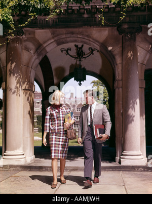 1960ER JAHRE MANN UND FRAU SCHÜLER MIT BÜCHERN AM ARCH FÜHRT ZU CAMPUS VIERECK PAAR ZWEI Stockfoto
