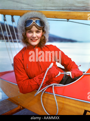1960ER JAHREN FRAU SITZT IM COCKPIT DES ICE BOOT HALTEN SEILE FÜR SEGEL HANDSCHUHE PELZMÜTZE-SCHUTZBRILLEN Stockfoto