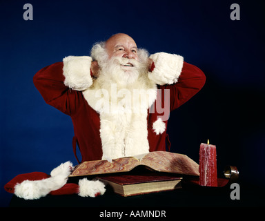 1950ER 1960ER JAHRE 1970ER JAHREN LÄCHELNDEN WEIHNACHTSMANN EINEN SACK VON SPIELZEUG PORTRAITSTUDIO INDOOR Stockfoto