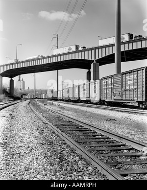 1970ER JAHREN ABGEWINKELT ANSICHT DER GÜTERZUG UNTERQUERUNG DER AUTOBAHNBRÜCKE Stockfoto