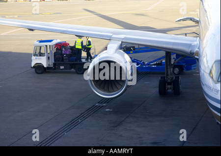 Gepäckabfertiger und Gepäck Fahrzeug hinter Flügel des Privileg Hola Airlines Boeing 757 256 Flugzeug sitzen auf Stand in dublin Stockfoto